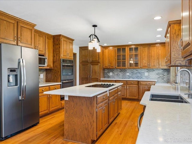48W142 Milnamow Dr, Maple Park, IL 60151 - kitchen with appliances with stainless steel finishes, brown cabinets, a center island, light countertops, and decorative backsplash