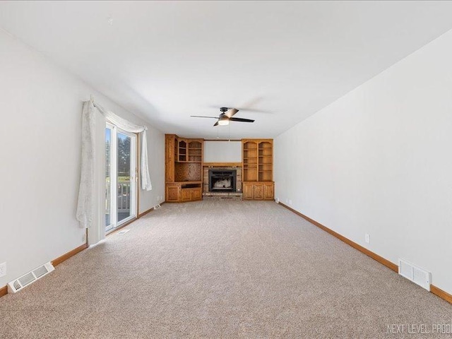 48W142 Milnamow Dr, Maple Park, IL 60151 - unfurnished living room featuring ceiling fan, light colored carpet, a fireplace, and built in shelves