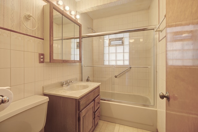 512 S Hebbard St, Joliet, IL 60433 - bathroom featuring tile walls, bath / shower combo with glass door, toilet, and vanity