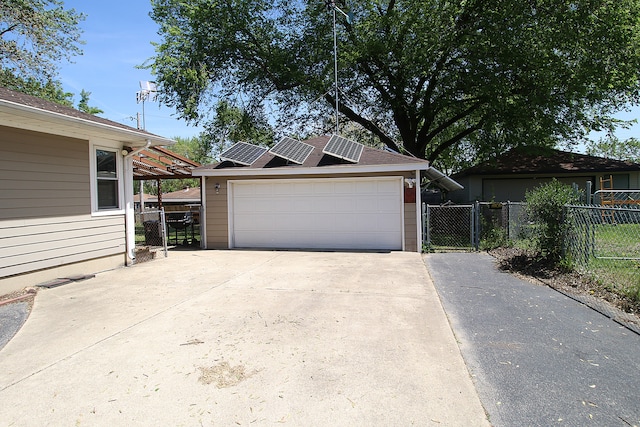 512 S Hebbard St, Joliet, IL 60433 - view of front facade with roof mounted solar panels, a garage, and fence