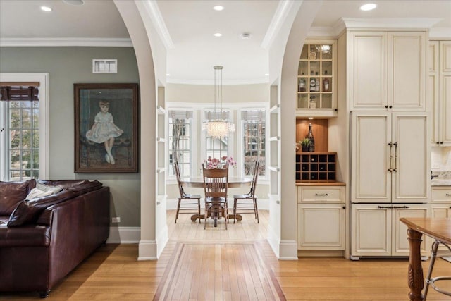2423 Harrison St, Evanston, IL 60201 - bar area with light wood-type flooring, arched walkways, crown molding, recessed lighting, and baseboards