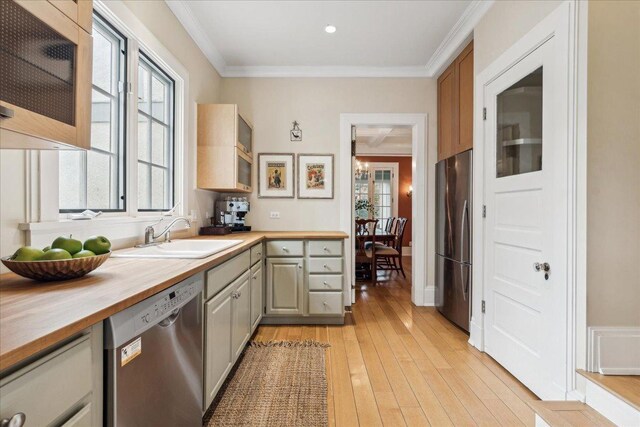 2423 Harrison St, Evanston, IL 60201 - kitchen featuring stainless steel appliances, a sink, wood counters, healthy amount of natural light, and crown molding