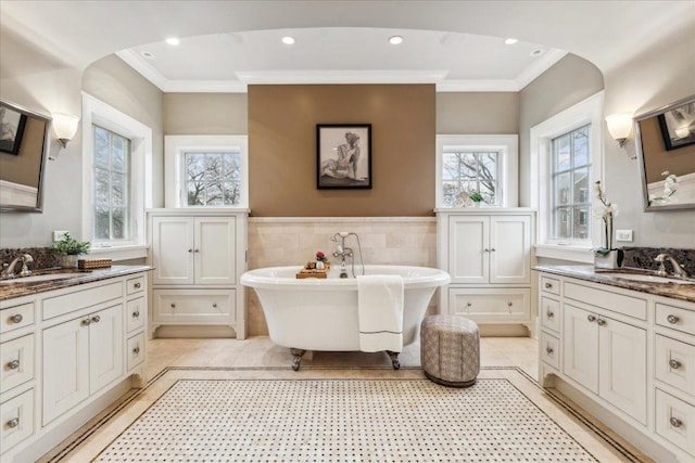 2423 Harrison St, Evanston, IL 60201 - full bathroom featuring crown molding, a soaking tub, two vanities, tile patterned flooring, and wainscoting