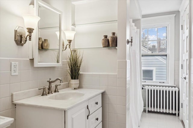 2423 Harrison St, Evanston, IL 60201 - bathroom with radiator, tile walls, vanity, and tile patterned floors