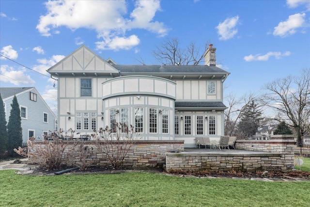 2423 Harrison St, Evanston, IL 60201 - back of house with a chimney, a patio, a lawn, board and batten siding, and a shingled roof
