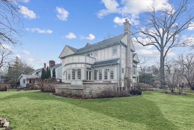 2423 Harrison St, Evanston, IL 60201 - rear view of property with a lawn, a chimney, board and batten siding, and french doors