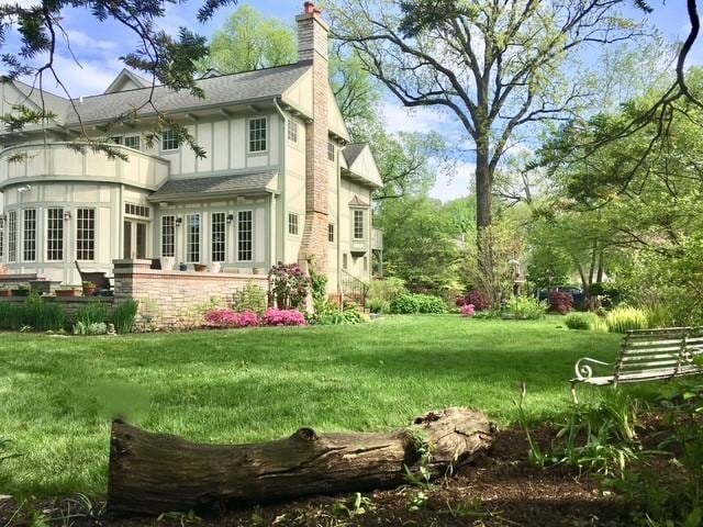 2423 Harrison St, Evanston, IL 60201 - back of house featuring a chimney, a lawn, a shingled roof, and a balcony