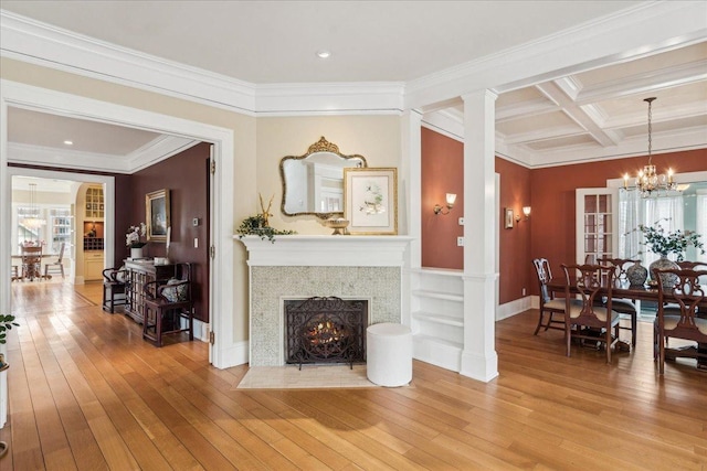 2423 Harrison St, Evanston, IL 60201 - living area featuring light wood-style flooring, a chandelier, crown molding, a fireplace with flush hearth, and beamed ceiling