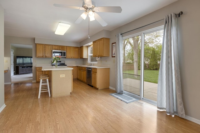 726 W Trl, Grayslake, IL 60030 - kitchen featuring stainless steel appliances, light wood finished floors, light countertops, a center island, and a kitchen breakfast bar