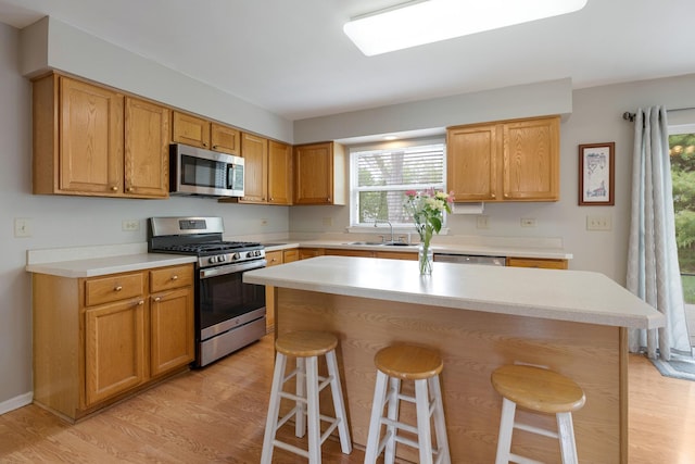 726 W Trl, Grayslake, IL 60030 - kitchen with stainless steel appliances, a sink, a kitchen bar, and light wood-type flooring