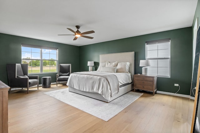 bedroom featuring light wood-style flooring, ceiling fan, and baseboards