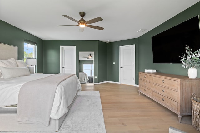 bedroom with light wood-style floors, multiple windows, baseboards, and ceiling fan