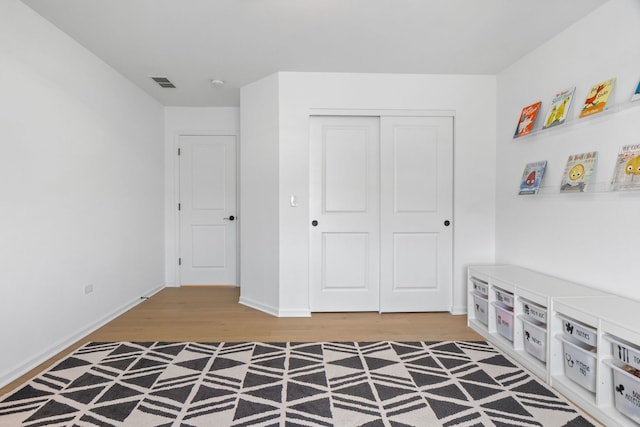 bedroom featuring wood finished floors, a closet, and baseboards