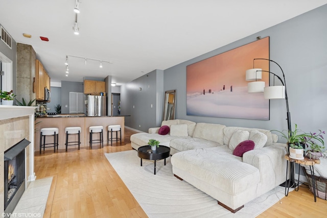 1212 N Wells St Unit 402, Chicago, IL 60610 - living area with light wood finished floors, a fireplace, and rail lighting