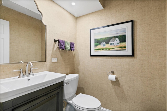 half bathroom with toilet and vanity