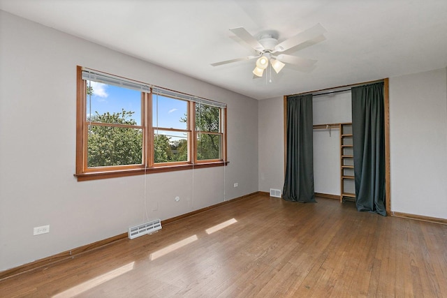 unfurnished bedroom featuring wood finished floors, baseboards, and a ceiling fan