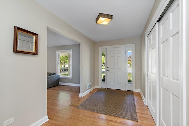 foyer entrance with light wood-type flooring and baseboards