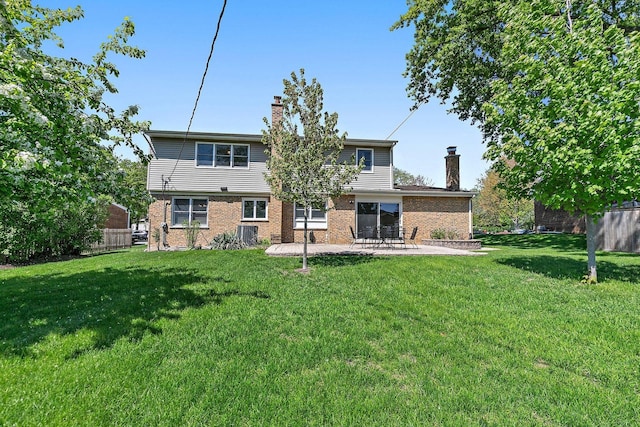 back of house with a chimney, a patio, and brick siding