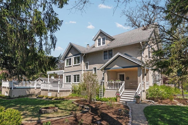 794 Dean Ave, Highland Park, IL 60035 - view of front of house featuring a porch, a front lawn, an outdoor fire pit, and stucco siding