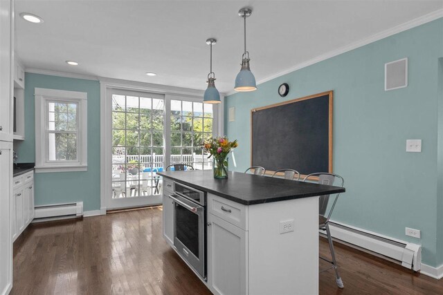 794 Dean Ave, Highland Park, IL 60035 - kitchen with a baseboard heating unit, stainless steel oven, dark countertops, a kitchen breakfast bar, and white cabinetry