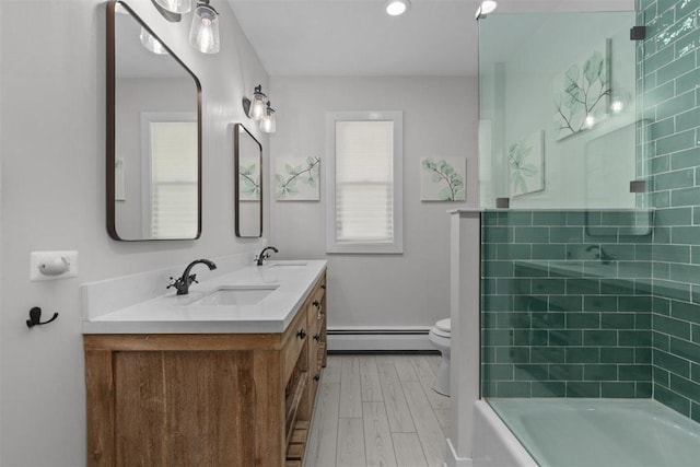 794 Dean Ave, Highland Park, IL 60035 - bathroom featuring baseboard heating, double vanity, wood finished floors, toilet, and  shower combination