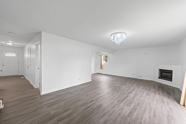 16215 S Trumbull Ave S, Markham, IL 60428 - unfurnished living room featuring dark wood-style floors, a glass covered fireplace, a chandelier, and baseboards
