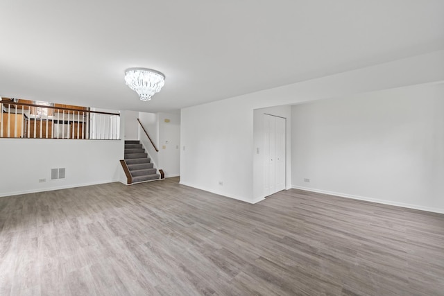 16215 S Trumbull Ave S, Markham, IL 60428 - unfurnished living room with wood finished floors, a chandelier, stairway, and baseboards