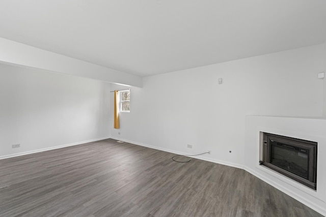 16215 S Trumbull Ave S, Markham, IL 60428 - unfurnished living room with dark wood-style flooring, baseboards, and a glass covered fireplace