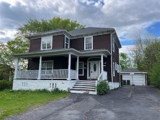 view of front of home featuring covered porch, an outbuilding, and a garage