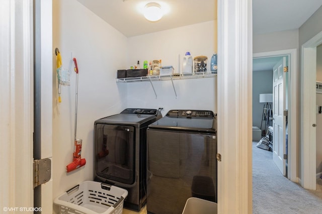 clothes washing area featuring washing machine and clothes dryer and carpet flooring