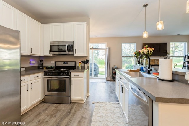 kitchen featuring appliances with stainless steel finishes, light wood-style flooring, a sink, and plenty of natural light