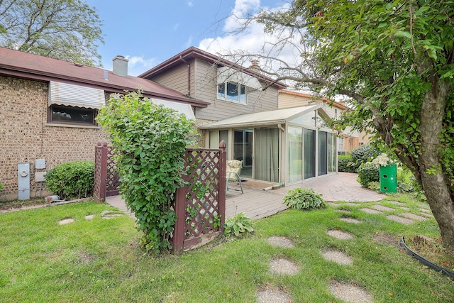 1116 N Old Fence Rd, Addison, IL 60101 - back of property with a sunroom, a chimney, a wooden deck, and a lawn