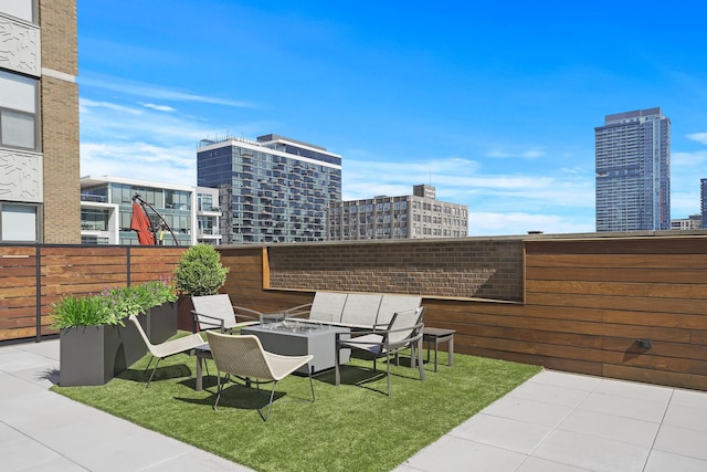 view of patio / terrace with an outdoor fire pit and a city view
