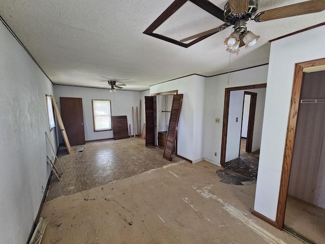 unfurnished living room with a ceiling fan and a textured ceiling