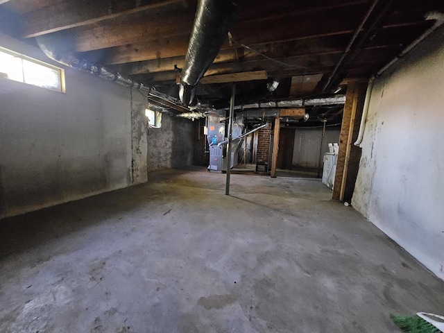 below grade area with heating unit and washer / clothes dryer