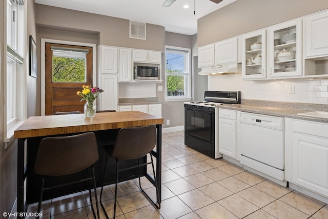 6329 N Hermitage Ave, Chicago, IL 60660 - kitchen with gas stove, dishwasher, stainless steel microwave, under cabinet range hood, and decorative backsplash