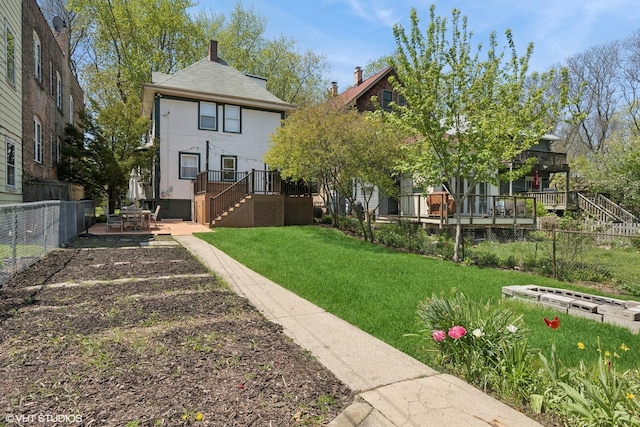 6329 N Hermitage Ave, Chicago, IL 60660 - back of property with stairway, a wooden deck, stucco siding, and a chimney