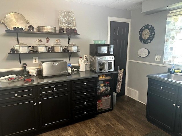 210 W S St, Sheffield, IL 61361 - bar area featuring a sink, dark wood-style flooring, and baseboards
