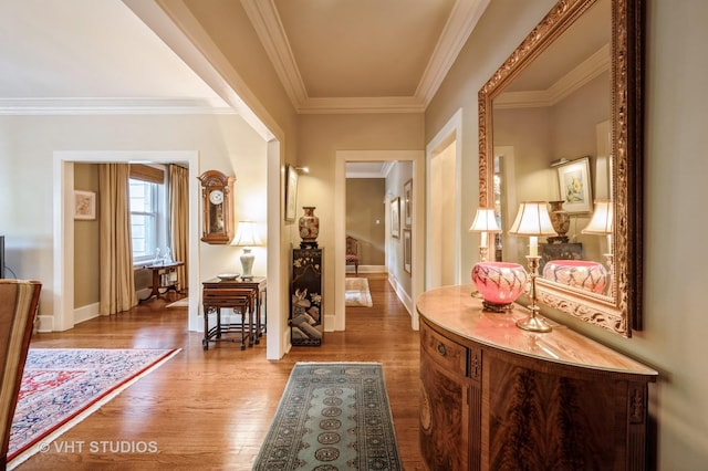 corridor featuring wood finished floors, baseboards, and crown molding