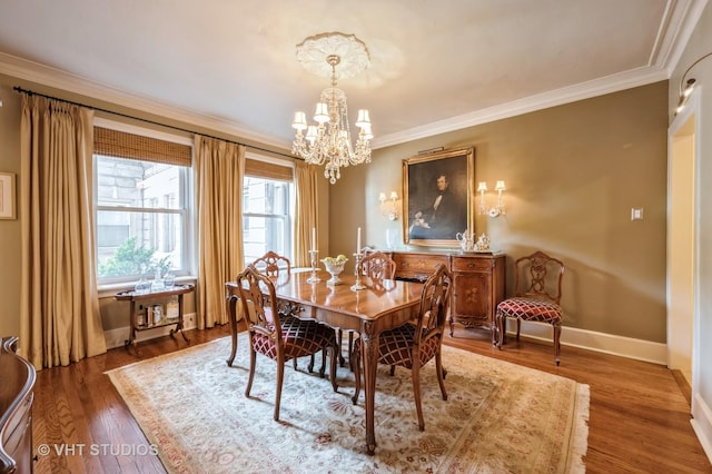dining room with baseboards, crown molding, a chandelier, and wood finished floors