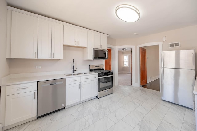 150 S 13th Ave, Maywood, IL 60153 - kitchen with stainless steel appliances, a sink, light countertops, and white cabinets