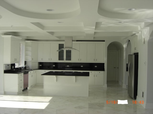 kitchen with appliances with stainless steel finishes, island range hood, white cabinets, a sink, and coffered ceiling