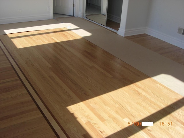spare room with wood finished floors and baseboards