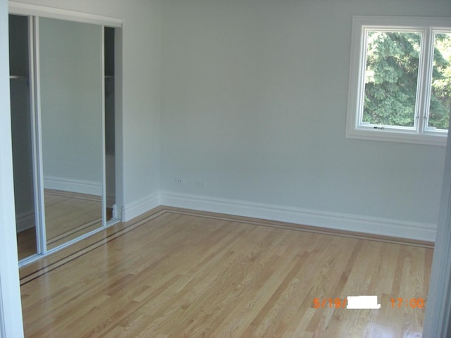 unfurnished bedroom with baseboards and wood finished floors