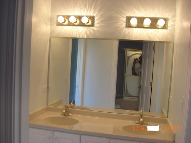 bathroom featuring double vanity and toilet