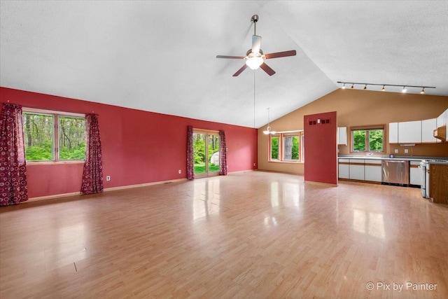 118 Centralia Pl, Poplar Grove, IL 61065 - unfurnished living room featuring light wood finished floors, vaulted ceiling, a ceiling fan, baseboards, and a chandelier