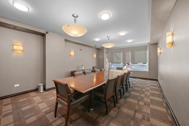 carpeted dining area featuring baseboards
