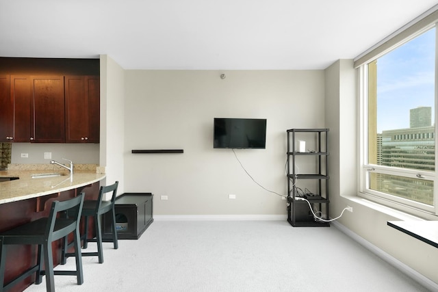 living area with light carpet and baseboards