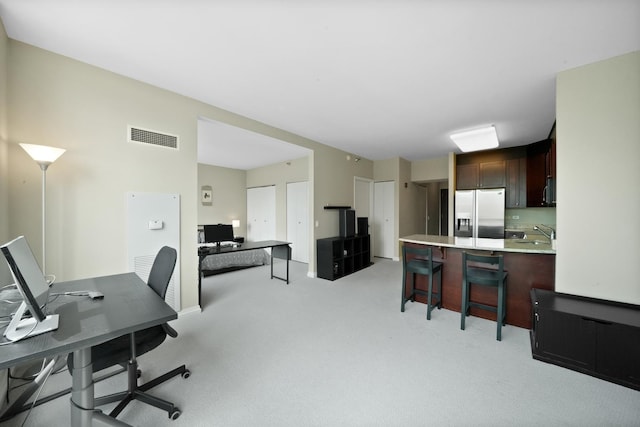 office space with light carpet and a sink