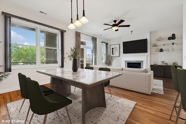 4727 N Clark St Unit 2S, Chicago, IL 60640 - dining area featuring healthy amount of natural light, light wood-type flooring, a ceiling fan, and a fireplace
